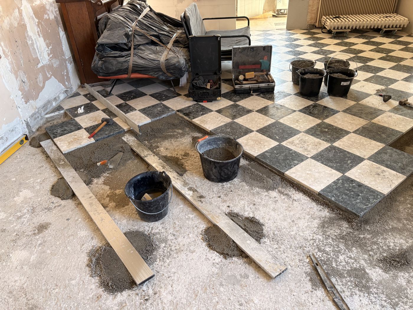Pose des carreaux terrazzo en cours, raccord avec l'existant